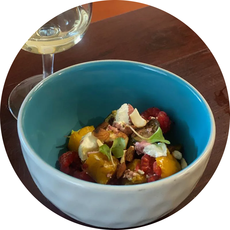Roasted squash, berries and soft cheese in a turquoise bowl