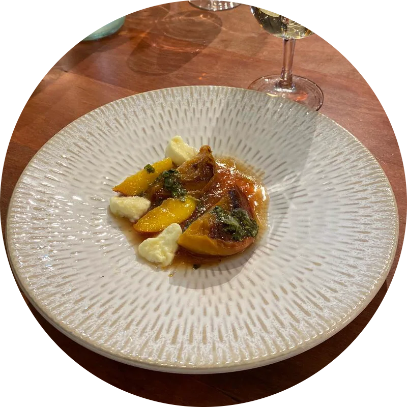 Citrus, roasted squash and herbs on a ridged white plate