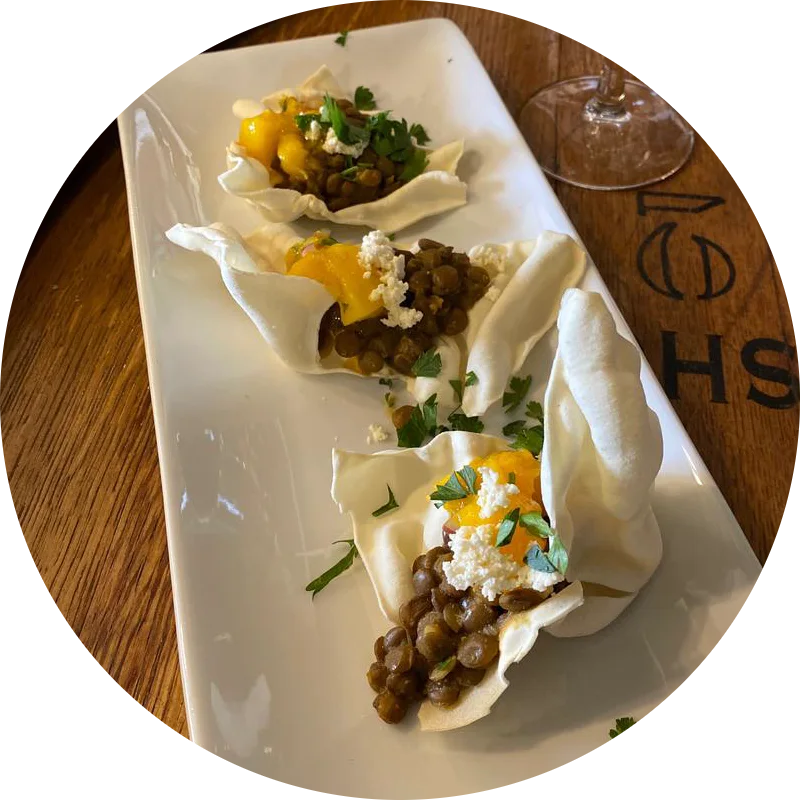 Filled pastry parcels with lentils and herbs on a barrel head